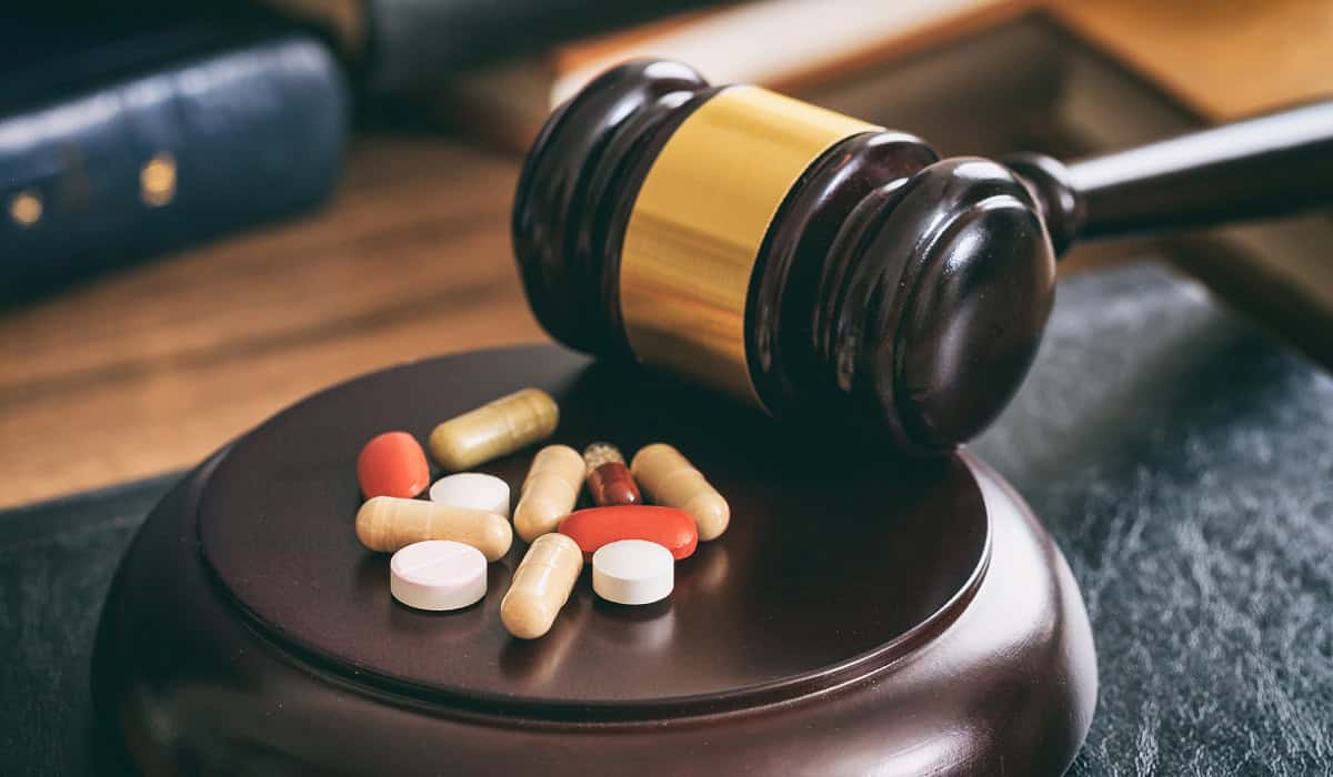 Judge gavel and drugs on a wooden desk